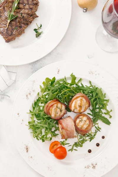 Biftek ve pastırma üstten görünüm Beyaz tabaklar roka ve biberiye dal ile hizmet alır