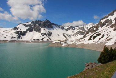 Bulutlu gökyüzü altında karlı dağlarda turkuaz Gölü manzaralı görünüm