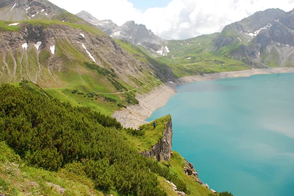 Bulutlu gökyüzü altında karlı dağlarda turkuaz Gölü manzaralı görünüm