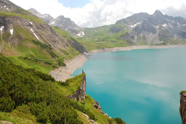 Bulutlu gökyüzü altında karlı dağlarda turkuaz Gölü manzaralı görünüm