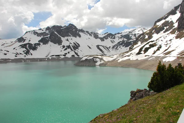 Bulutlu gökyüzü altında karlı dağlarda turkuaz Gölü manzaralı görünüm