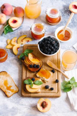 Tost kayısı reçelli ekmek ve beyaz ahşap masa yapraklarda ile taze meyve. Lezzetli kahvaltı.