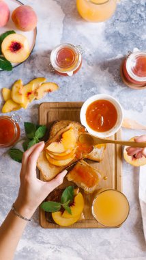 Tost kayısı reçelli ekmek ve beyaz ahşap masa yapraklarda ile taze meyve. Lezzetli kahvaltı.