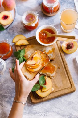 Tost kayısı reçelli ekmek ve beyaz ahşap masa yapraklarda ile taze meyve. Lezzetli kahvaltı.