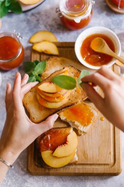 Tost kayısı reçelli ekmek ve beyaz ahşap masa yapraklarda ile taze meyve. Lezzetli kahvaltı.