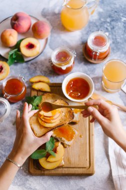 Tost kayısı reçelli ekmek ve beyaz ahşap masa yapraklarda ile taze meyve. Lezzetli kahvaltı.
