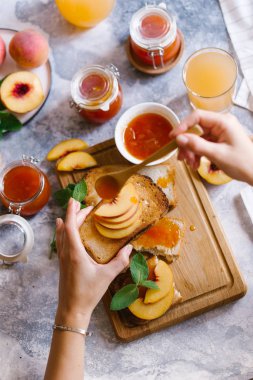 Tost kayısı reçelli ekmek ve beyaz ahşap masa yapraklarda ile taze meyve. Lezzetli kahvaltı.