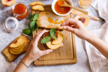 Tost kayısı reçelli ekmek ve beyaz ahşap masa yapraklarda ile taze meyve. Lezzetli kahvaltı.