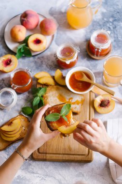 Tost kayısı reçelli ekmek ve beyaz ahşap masa yapraklarda ile taze meyve. Lezzetli kahvaltı.