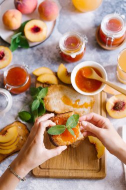 Tost kayısı reçelli ekmek ve beyaz ahşap masa yapraklarda ile taze meyve. Lezzetli kahvaltı.