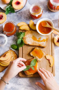 Tost kayısı reçelli ekmek ve beyaz ahşap masa yapraklarda ile taze meyve. Lezzetli kahvaltı.