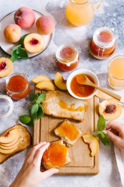 Tost kayısı reçelli ekmek ve beyaz ahşap masa yapraklarda ile taze meyve. Lezzetli kahvaltı.