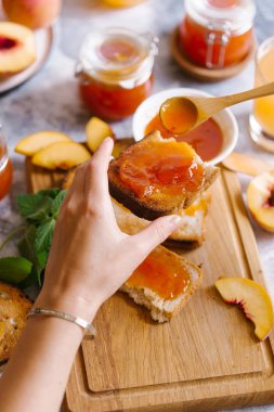 Tost kayısı reçelli ekmek ve beyaz ahşap masa yapraklarda ile taze meyve. Lezzetli kahvaltı.