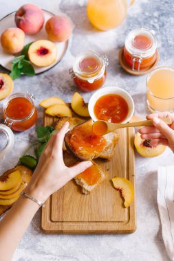 Tost kayısı reçelli ekmek ve beyaz ahşap masa yapraklarda ile taze meyve. Lezzetli kahvaltı.