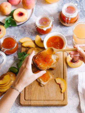 Tost kayısı reçelli ekmek ve beyaz ahşap masa yapraklarda ile taze meyve. Lezzetli kahvaltı.