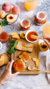 Tost kayısı reçelli ekmek ve beyaz ahşap masa yapraklarda ile taze meyve. Lezzetli kahvaltı.