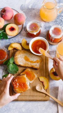 Tost kayısı reçelli ekmek ve beyaz ahşap masa yapraklarda ile taze meyve. Lezzetli kahvaltı.