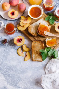 Tost kayısı reçelli ekmek ve beyaz ahşap masa yapraklarda ile taze meyve. Lezzetli kahvaltı.