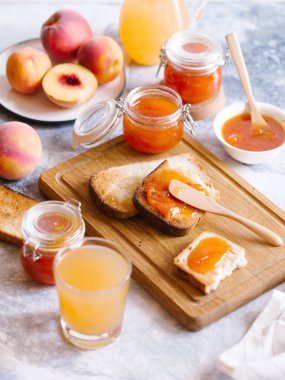 Tost kayısı reçelli ekmek ve beyaz ahşap masa yapraklarda ile taze meyve. Lezzetli kahvaltı.