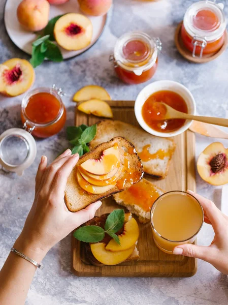 Tost kayısı reçelli ekmek ve beyaz ahşap masa yapraklarda ile taze meyve. Lezzetli kahvaltı.