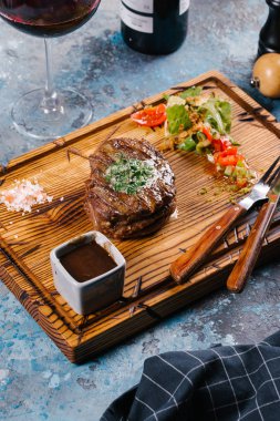 Taze orta çiğ biftek Ahşap Doğrama tahtası üzerinde sebze salatası ile servis