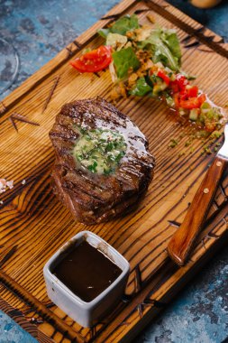 Taze orta çiğ biftek Ahşap Doğrama tahtası üzerinde sebze salatası ile servis