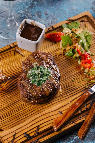 Taze orta çiğ biftek Ahşap Doğrama tahtası üzerinde sebze salatası ile servis