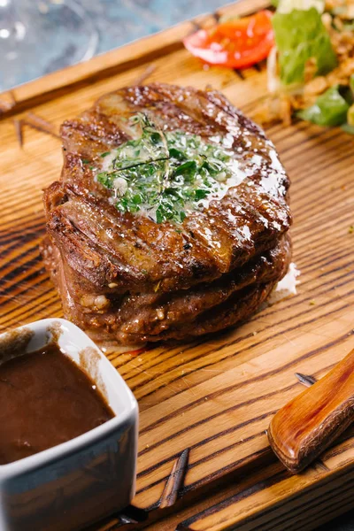 Taze orta çiğ biftek Ahşap Doğrama tahtası üzerinde sebze salatası ile servis