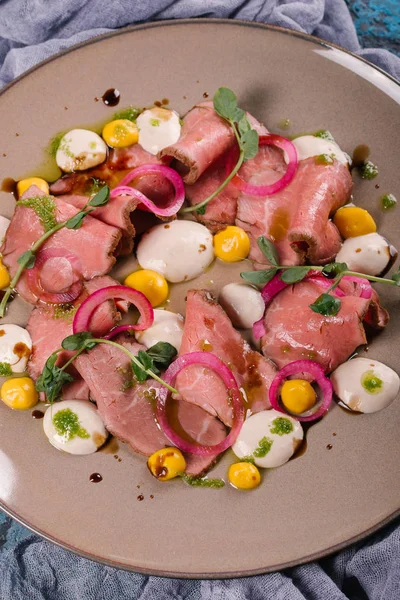 Gri plaka üzerinde sos ile servis taze jambon güveç