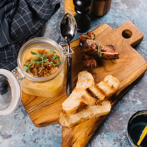 Creme çorbası tost ve Ahşap Doğrama tahtası üzerinde kaburga cam