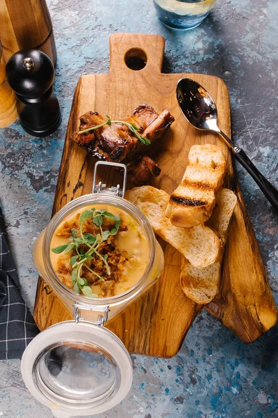 Creme çorbası tost ve Ahşap Doğrama tahtası üzerinde kaburga cam