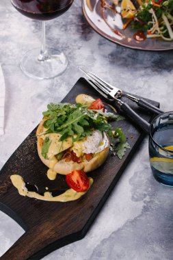 Taze topuz pastırma ile servis edilir, Benedict Ahşap Doğrama tahtası sosu altında yumurta