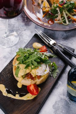 Taze topuz pastırma ile servis edilir, Benedict Ahşap Doğrama tahtası sosu altında yumurta