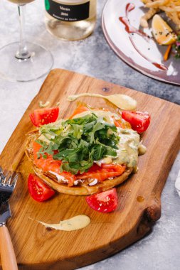 Somon, roka ve Ahşap Doğrama tahtası üzerinde sos ile servis topuz