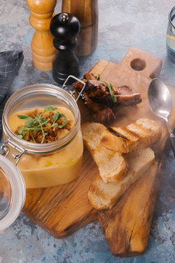 Creme çorbası tost ve Ahşap Doğrama tahtası üzerinde kaburga cam