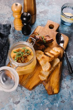 Creme çorbası tost ve Ahşap Doğrama tahtası üzerinde kaburga cam