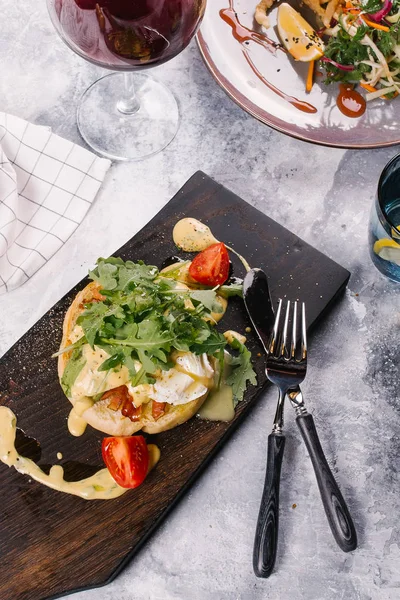 Taze topuz pastırma ile servis edilir, Benedict Ahşap Doğrama tahtası sosu altında yumurta