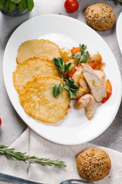 Patates pancakes ile haşlanmış tavuk beyaz tabakta servis