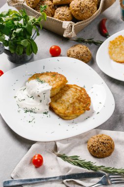 Ekşi krema ve dereotu beyaz plaka üzerinde patates pancakes