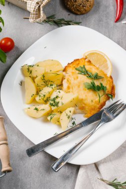 Haşlanmış patates ve beyaz plaka üzerinde limon dilimi ile servis taze hamburger biftek