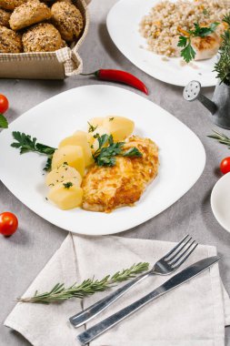 Beyaz tabakta haşlanmış patates ile taze hamburger biftek servis