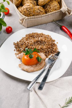 Boilden arpa kabuğu çıkarılmış tane beyaz tabakta dal maydanoz ile servis tavuk sosis ile