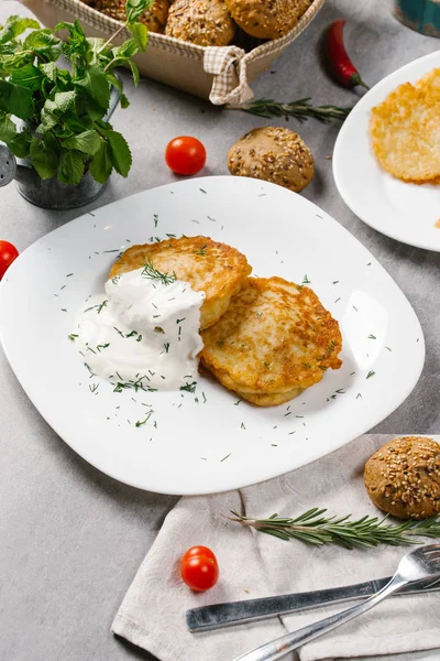 Ekşi krema ve dereotu beyaz plaka üzerinde patates pancakes