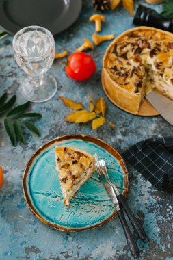 Dilim taze quiche yabani mantar ile mavi taş arka plan üzerinde tabakta