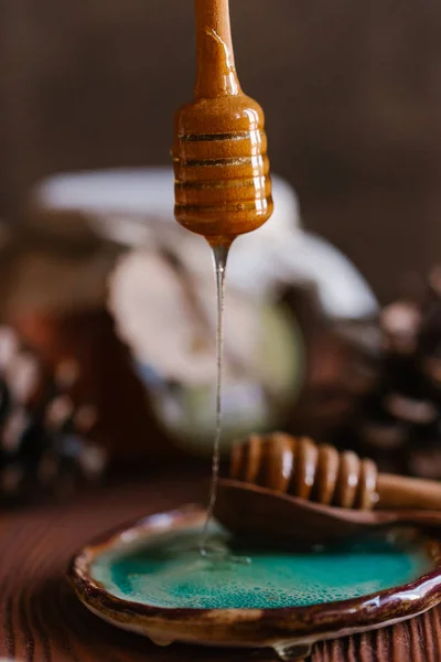 蓝色陶瓷板上的蜂蜜在木质背景动的新鲜蜂蜜 — 图库照片