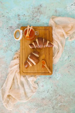 Grunge mavi beton zemin üzerine Ahşap Doğrama tahtası üzerinde taze ev yapımı kruvasan ile kayısı reçel