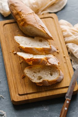 Ahşap kesme tahtası üzerinde karanlık masa üzerinde kesme somun ekmek görünümünü kapat