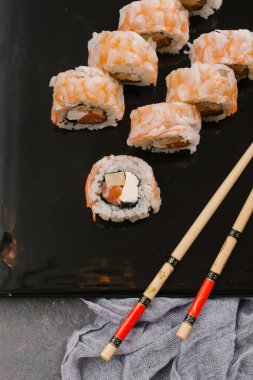 Üstten görünüm taze geleneksel Japon ile chopsticks beton zemin üzerine siyah plaka üzerinde rulo