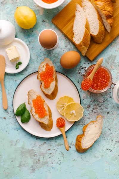 Fransız baget ile tereyağı ve mavi beton zemin üzerine kırmızı havyar servis üstten görünüm