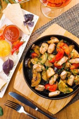 Üstten görünüm sıcak Pan kavrulmuş patates, sebze ve domuz üzerinde ahşap kurulunda görev yapmaktadır.